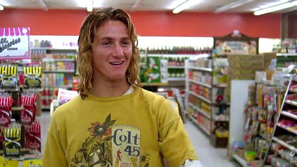 Sean Penn as Jeff Spicoli in Fast Times at Ridgemont High, in a yellow Colt 45 tee in a shop aisle