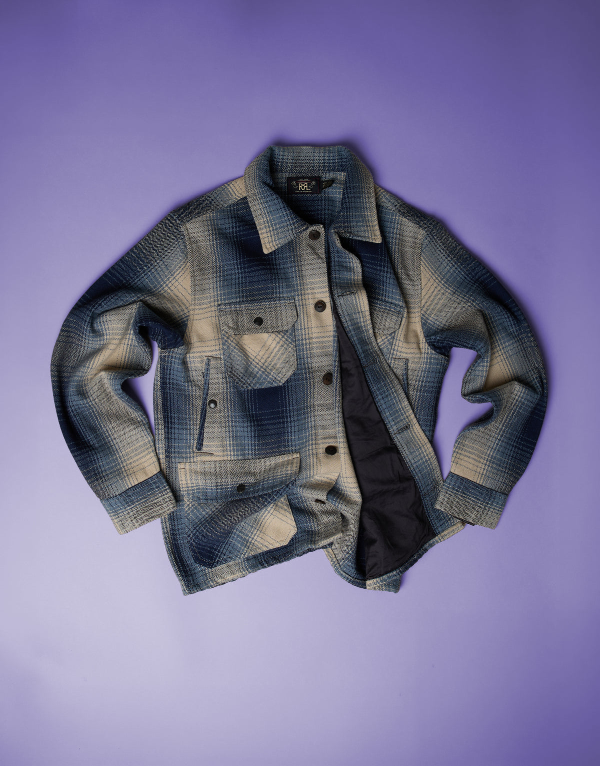RRL blue and cream checked overshirt with button front and chest pockets, photographed against a purple background
