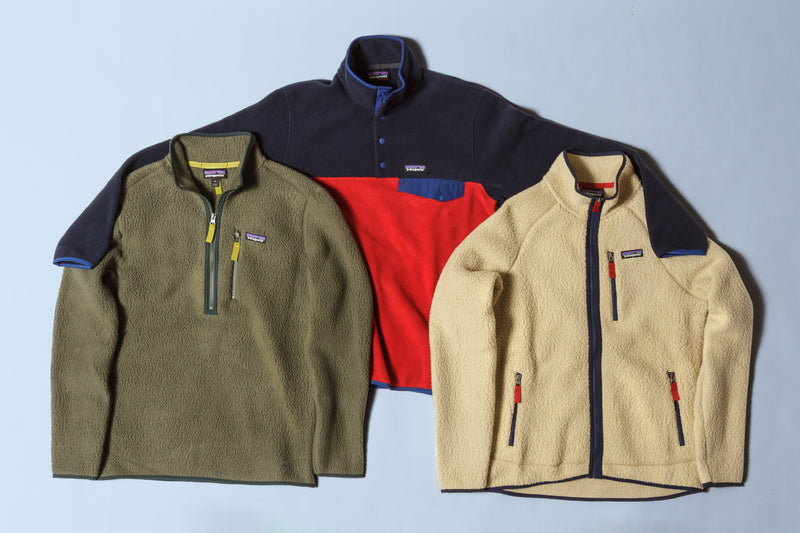 Three vintage Patagonia fleece pullovers in olive, navy and red, and cream, photographed together